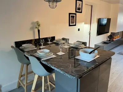 a kitchen with a table with plates and wine glasses at Camellia Cottage in Camborne