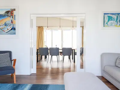 a living room with a dining room table and chairs at Beach Haven in Perranporth