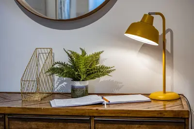 a desk with a lamp and a plant on it at Beach Haven in Perranporth