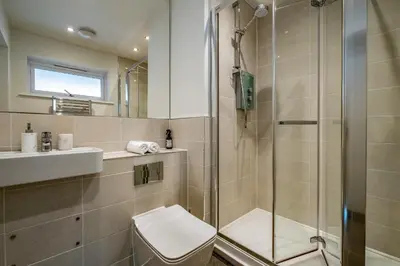 a bathroom with a shower and a toilet and a sink at Beach Haven in Perranporth