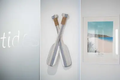 a pair of tooth brushes hanging on a wall at Tides in Carbis Bay