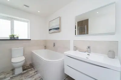 a white bathroom with a toilet and a sink at Tides in Carbis Bay