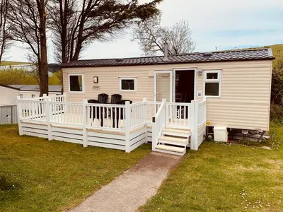 a white mobile home with a porch and a staircase at 94 Newquay Bay Resort pet friendly in Newquay