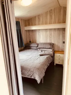 a small bedroom with a bed and a table at 94 Newquay Bay Resort pet friendly in Newquay