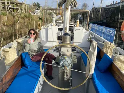 a woman sitting on the front of a boat at Stunning Yacht Sea Lion in Charlestown Harbour, Cornwall in Charlestown
