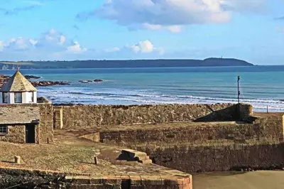 a view of the ocean and a stone wall at Stunning Yacht Sea Lion in Charlestown Harbour, Cornwall in Charlestown