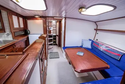 a living room with a blue couch in a boat at Stunning Yacht Sea Lion in Charlestown Harbour, Cornwall in Charlestown