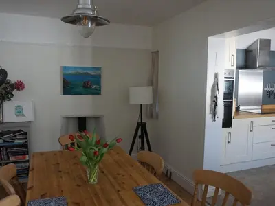 a dining room table with a vase of flowers on it at The Porthole in Port Isaac