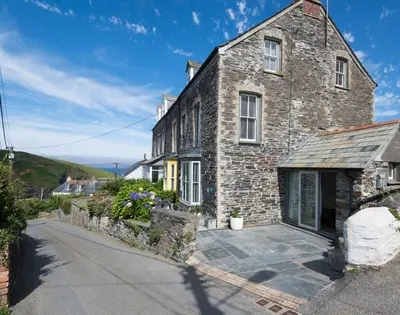 a large stone house with a driveway in front of it at Albany in Port Isaac