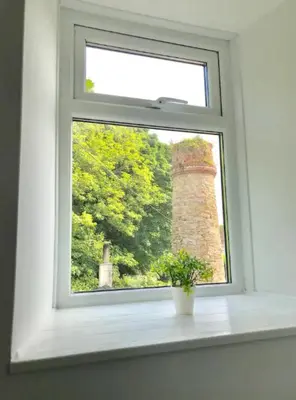 a window with a plant sitting on a window sill at A woodland retreat - Apartment in converted mill in Helston
