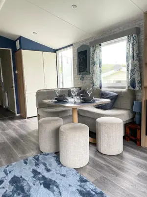 a living room with a couch and a table and stools at Newquay Bay Resort - Sea Breeze 61 in Newquay