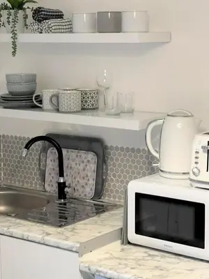 a kitchen counter with a microwave and a sink at Cosy retreat in beautiful Cornwall in Helston