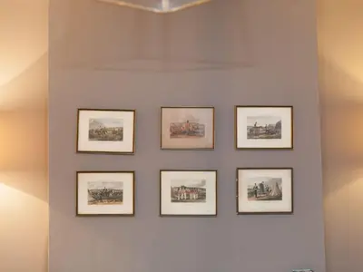 a wall with four framed pictures on a wall at Marchbourne in St Ives