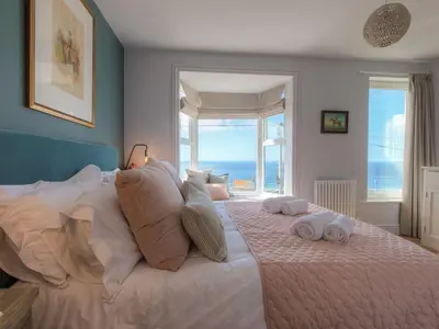 a bedroom with a large bed with towels on it at Marchbourne in St Ives