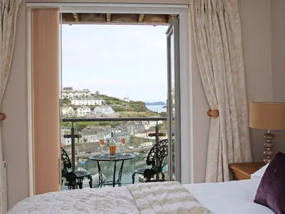 a room with a bed and a large window with a view at Wheal Kendall in St Austell