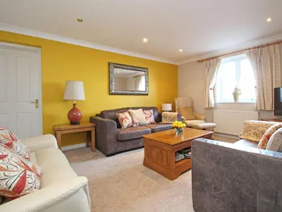 a living room with a couch and a table at Wheal Kendall in St Austell