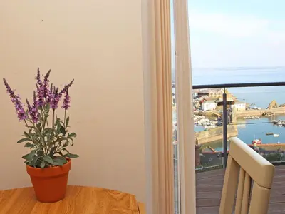 a table with a potted plant and a view of the ocean at Wheal Kendall in St Austell