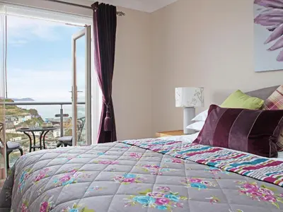 a bedroom with a bed and a window with a view at Wheal Kendall in St Austell