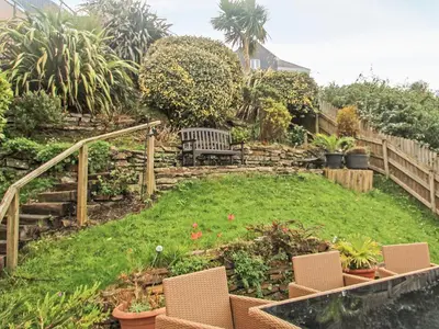 a garden with a bench and stairs and plants at Wheal Kendall in St Austell