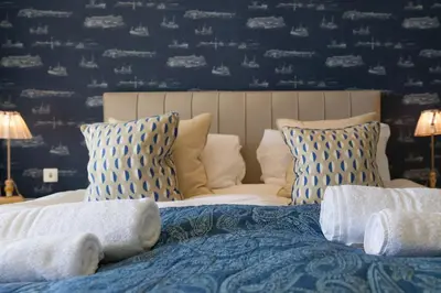 a bedroom with a bed with blue and white pillows at Peninsula Apartment 2 in St Ives