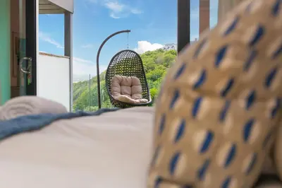 a person is sitting in a wicker chair on a balcony at Peninsula Apartment 2 in St Ives