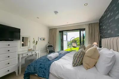 a bedroom with a bed and a desk and a television at Peninsula Apartment 2 in St Ives