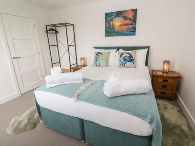 a bedroom with a large bed with two pillows at 3 Praa Cove in Penzance