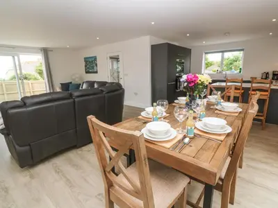 a dining room and living room with a table and chairs at 3 Praa Cove in Penzance