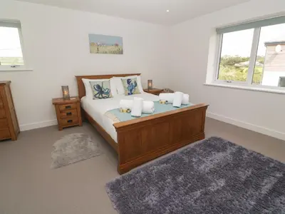 a bedroom with a bed with white sheets and pillows at 3 Praa Cove in Penzance