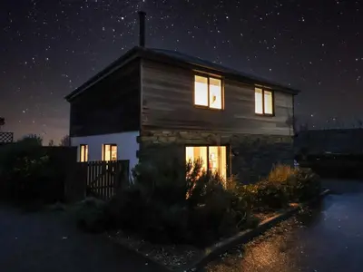 a house with the lights on at night at 3 Praa Cove in Penzance