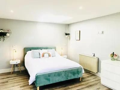 a bedroom with a bed with a green headboard at Detached, peaceful, spacious with easy access and very large garden in Wadebridge