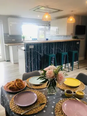 a table with plates and flowers on it in a kitchen at Detached, peaceful, spacious with easy access and very large garden in Wadebridge