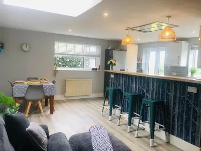 a kitchen and living room with a couch and a table at Detached, peaceful, spacious with easy access and very large garden in Wadebridge