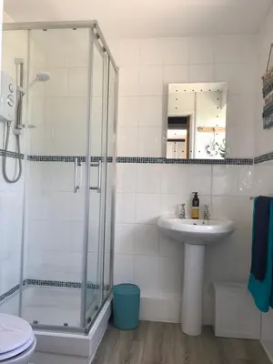 a bathroom with a glass shower and a sink at Detached, peaceful, spacious with easy access and very large garden in Wadebridge