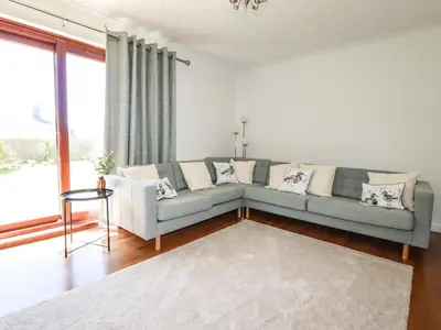 a living room with a couch and a large window at Chyrosen in Redruth