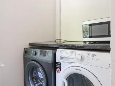 a microwave and a washing machine in a room at Chyrosen in Redruth