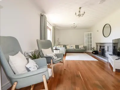 a living room with two chairs and a fireplace at Chyrosen in Redruth