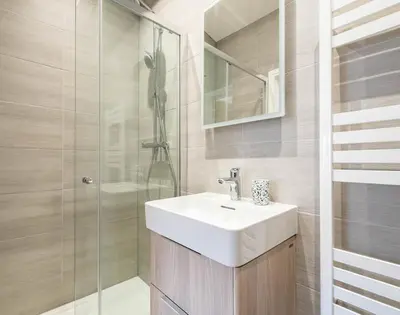 a bathroom with a white sink and a shower at Artemis in Saint Minver