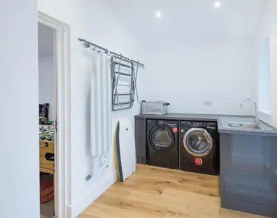 a laundry room with a washer and a washing machine at Artemis in Saint Minver