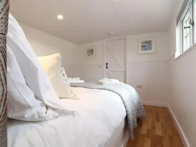 a white bed in a room with a window at Sebright in St Austell