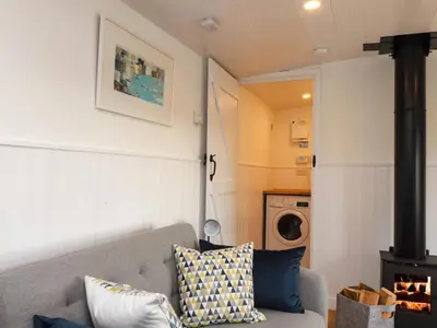 a living room with a couch and a stove at Sebright in St Austell