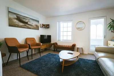 a living room with a couch and a tv at The Old Pirates Lookout in Falmouth