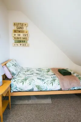 a bed sitting in a room next to a wall at The Old Captains Lookout in Falmouth