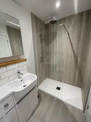 a bathroom with a shower and a white sink at The Old Captains Lookout in Falmouth