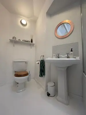 a bathroom with a toilet and a sink at Cockleshell Cottage in Falmouth