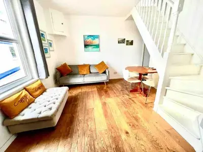 a living room with a couch and a table at Cockleshell Cottage in Falmouth