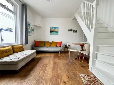 a living room with a couch and a table at Cockleshell Cottage in Falmouth