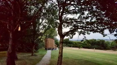 a barn in the middle of a field with trees at Hare's Hut in Saint Clement