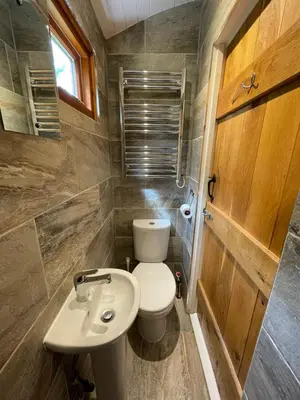 a small bathroom with a toilet and a sink at Hare's Hut in Saint Clement