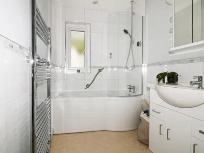 a white bathroom with a tub and a sink at Creekside House in Fowey